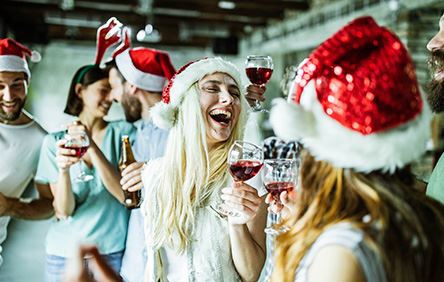 group of people celebrating, posing in Santa hats